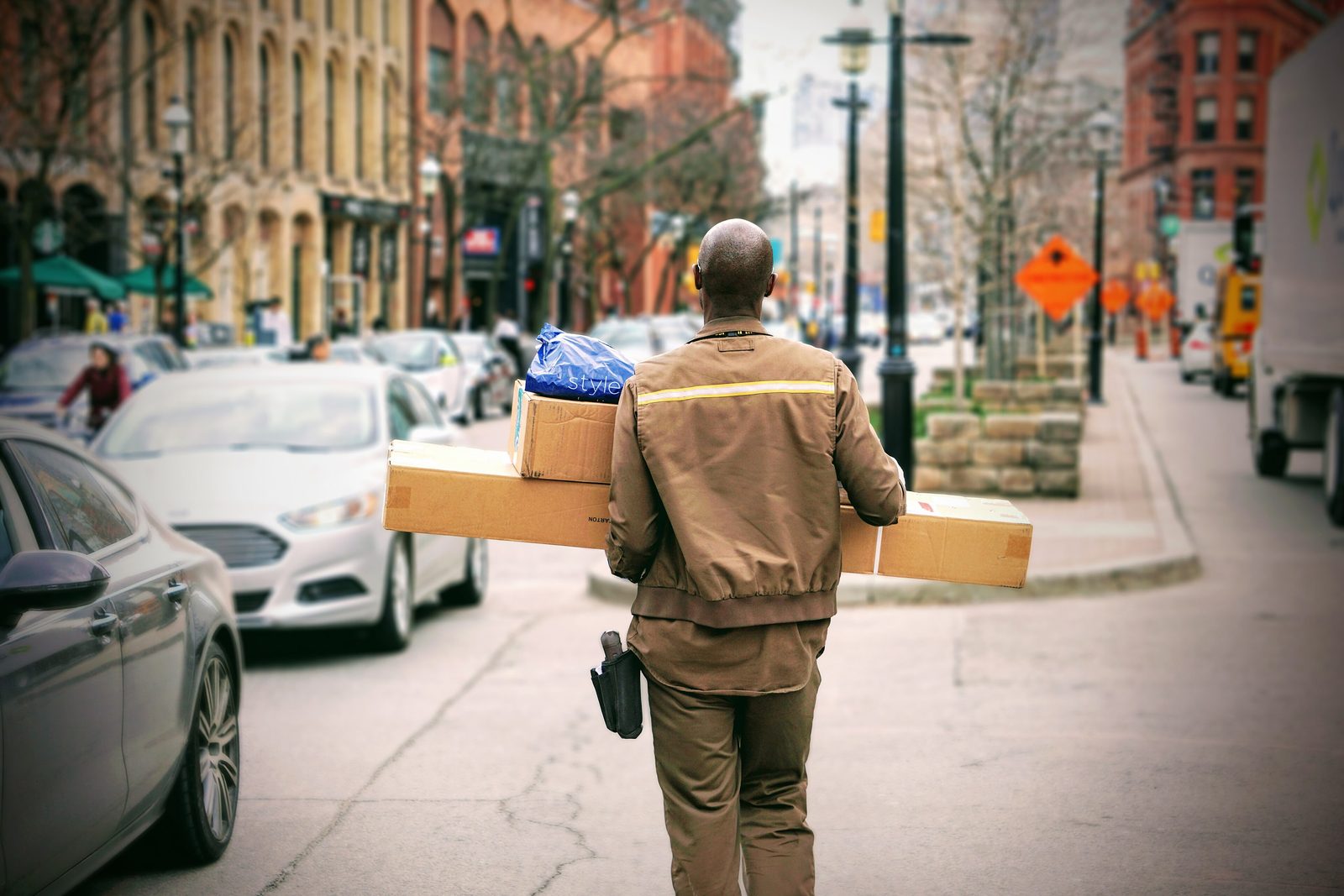 Delivery worker carrying parcels on a city street